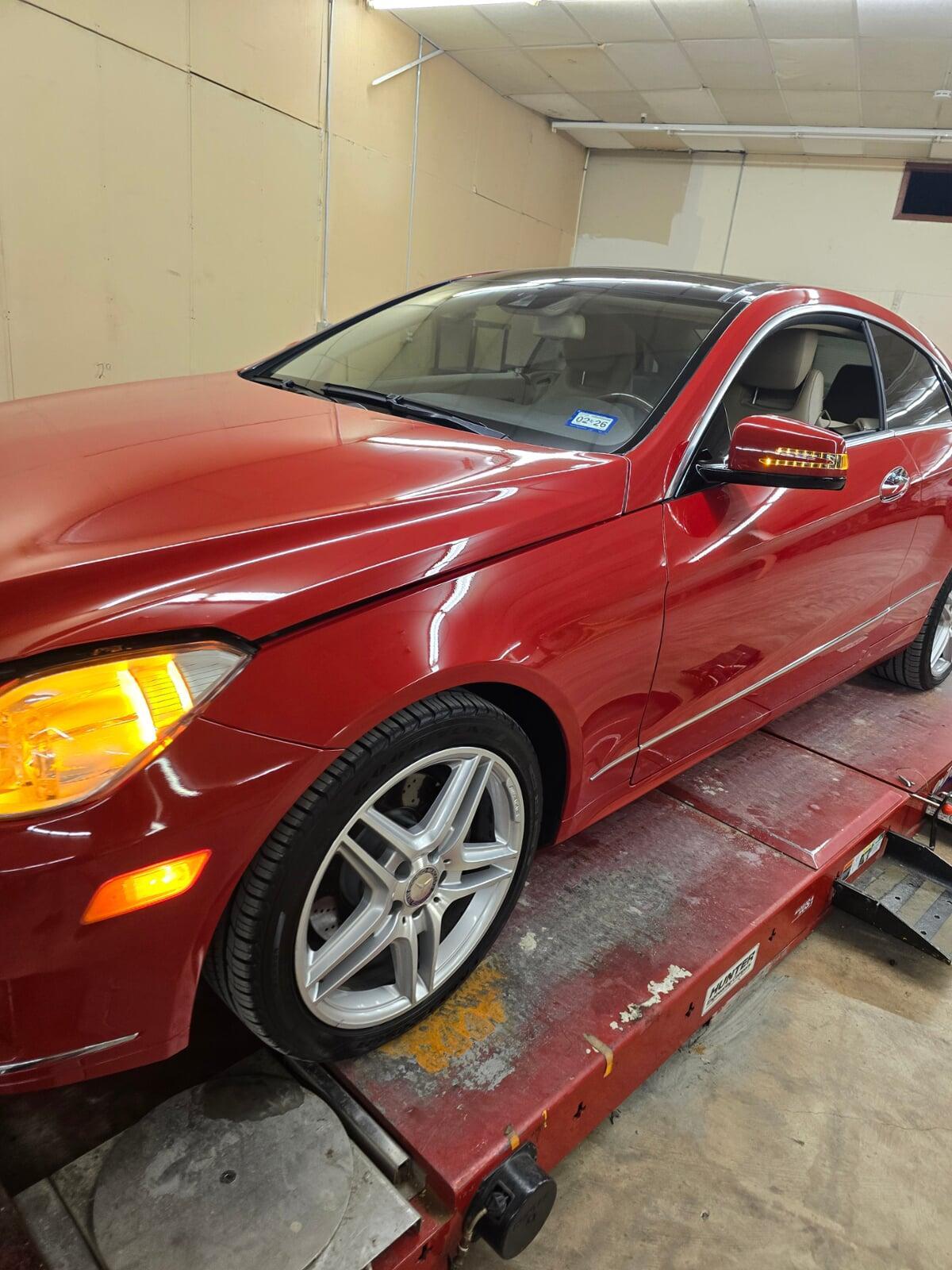 Red Mercedes-Benz on alignment rack